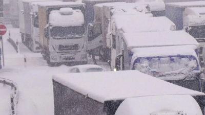 Lastwagen stecken im Stau auf der schneebedeckten Autobahn 5 bei Alsfeld fest. (Foto: Bernd März/dpa)