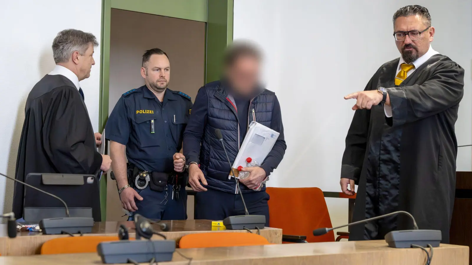 Einer der Angeklagten bei Prozessbeginn. (Archivbild).  (Foto: Peter Kneffel/dpa)