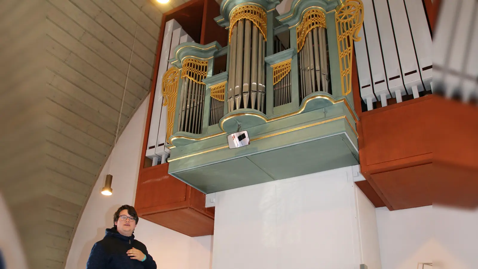 Pfarrer Jonathan Gerber erläutert das Hauptwerk der Orgel in der Nikolauskirche in Schalkhausen. (Foto: Alexander Biernoth)