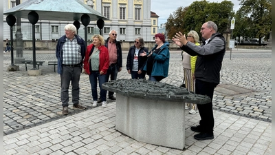 Viele Touristen lassen sich bei einer Führung – hier mit Historiker Alexander Biernoth (rechts) am Bronze-Tastmodell der Stadt auf dem Schlossplatz – die Geheimnisse Ansbachs erklären. (Archivbild: Oliver Herbst)