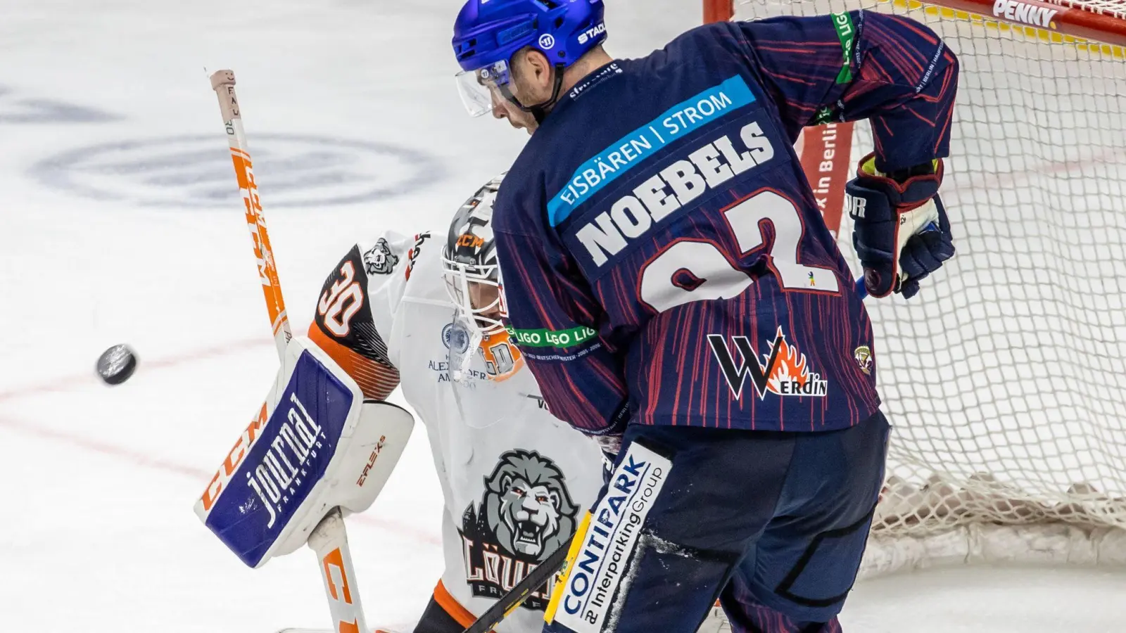 Ein Torhüter kämpft gegen Berlins Marcel Noebels (r) um den Puck. (Foto: Andreas Gora/dpa/Archivbild)