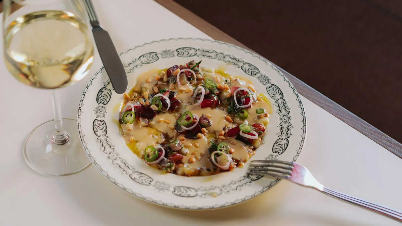 Das Trauben-Gremolata ist bei dem Carpaccio im „béné by Benedict“ der spannende Twist zu den cremigen Auberginen-Scheiben.   (Foto: Studio Kroll/dpa-tmn)