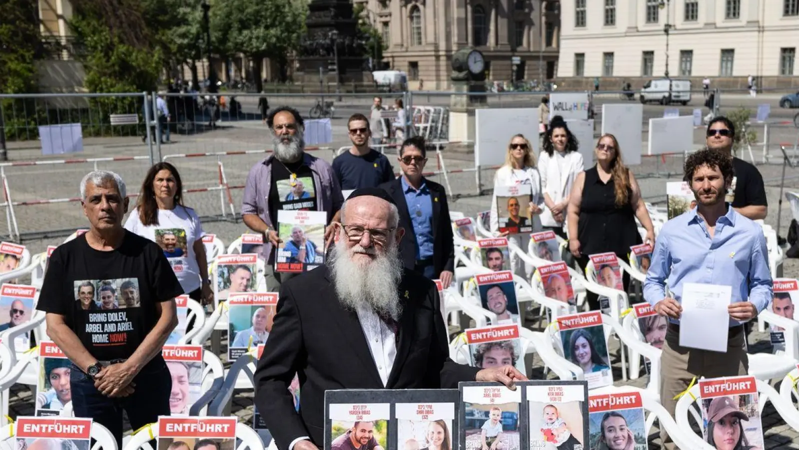 Angehöre von Geiseln und Teilnehmer der Veranstaltung stehen auf dem Beblplatz. Der Bebelplatz soll für einige Wochen symbolisch zum „Platz der Hamas-Geiseln“ werden. Es wurden auch 132 leere Stühle aufgestellt. (Foto: Hannes P. Albert/dpa)