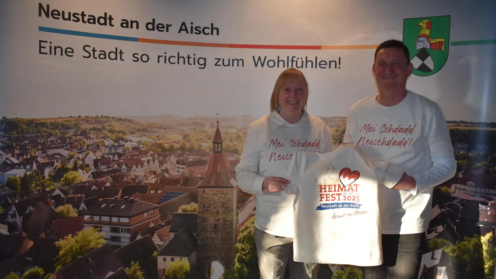 Sabine Fink und Rüdiger Eisen präsentieren die T-Shirts, die es zum Heimatfest gibt. . (Foto: Niephaus)