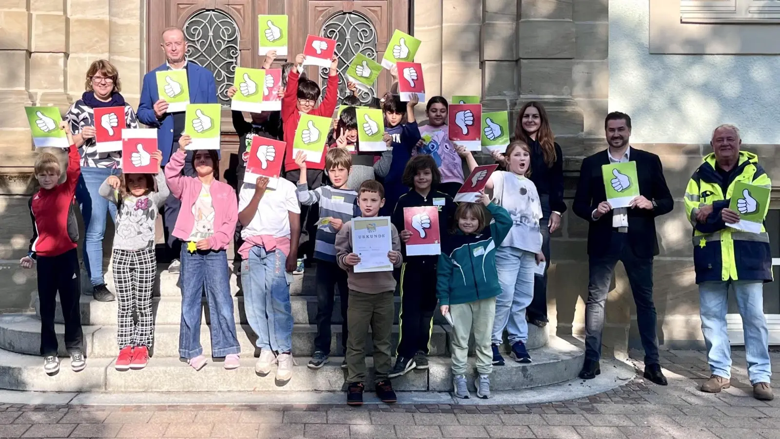 Grün oder rot? Die Grundschülerinnen und Grundschüler der Luitpoldschule zeigen, wie sie an der Feuchtwanger Straße über das Tempo der Autos urteilen. (Foto: Antonia Hoppert)