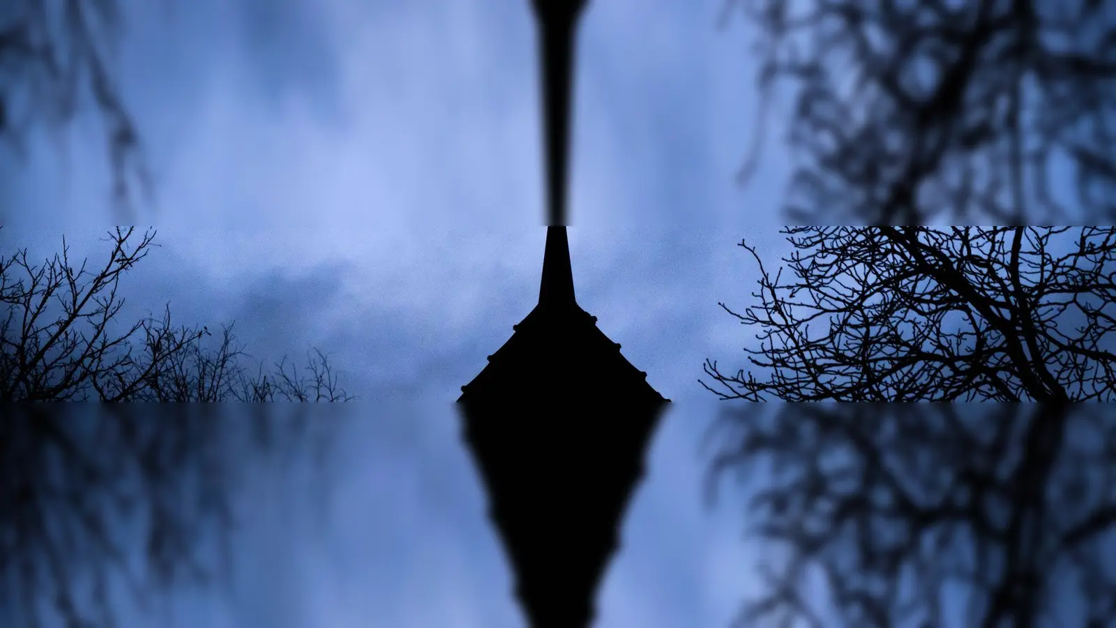 Dunkle Wolken ziehen über das Kreuz auf einer Kirche hinweg. (Foto: Julian Stratenschulte/dpa/Symbolbild)