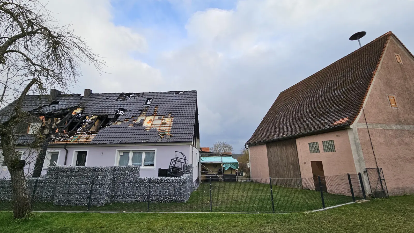 Ironie des Schicksals: Das Wohnhaus, in dem es vor wenigen Tagen brannte, steht direkt hinter dem alten Feuerwehrhaus in Neunkirchen (rechts im Bild). Der avisierte Neubau-Standort bei Wiedersbach hätte den Rettungskräften wertvolle Zeit bis zum Erreichen des Einsatzortes gekostet, mahnen Kritiker. (Foto: Wolfgang Grebenhof)