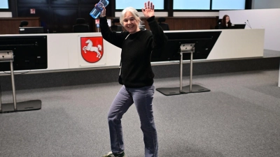 Daniela Klette winkt freudig, wenn Unterstützer im Publikum sitzen. (Archivbild) (Foto: Sina Schuldt/dpa)