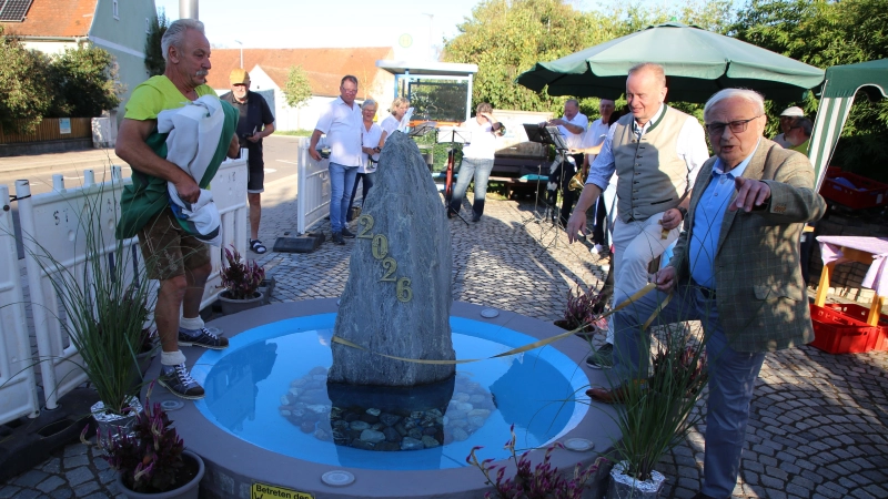 Hans Probst, Oberbürgermeister Thomas Deffner und Friedrich Hilterhaus (von links) enthüllten den neuen Brunnen in der Mitte Kurzendorfs.  (Foto: Alexander Biernoth)