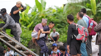 Ein Mann wird im Katastrophengebiet in Nepal von einem Polizisten auf dem Rücken getragen. (Foto: Rajesh Kumar Singh/AP/dpa)