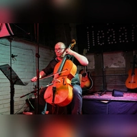Greift zwischen seinen Gitarrenliedern gern zum Cello: Karl Henniger beim Konzert in der Kunstmühle Flachslanden. (Foto: Martina Kramer)