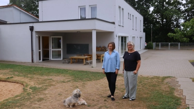 Das Lummerland will den Garten auch bei viel Sonnenschein nutzen. Darauf weisen Leiterin Manuela Höhn (rechts) und Christiane Halenke vom Diakonischen Werk Ansbach hin. Mit dabei ist Hund Cooper. (Foto: Oliver Herbst)