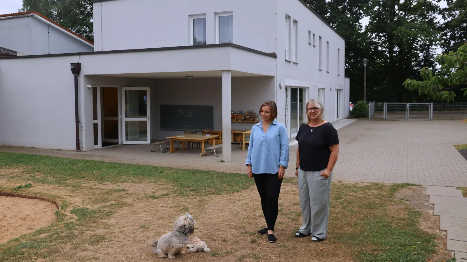 Das Lummerland will den Garten auch bei viel Sonnenschein nutzen. Darauf weisen Leiterin Manuela Höhn (rechts) und Christiane Halenke vom Diakonischen Werk Ansbach hin. Mit dabei ist Hund Cooper. (Foto: Oliver Herbst)