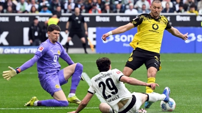 BVB-Torwart Gregor Kobel (l) und Waldemat Anton (r) im Duell mit Gladbachs Joe Scally.  (Foto: Federico Gambarini/dpa)