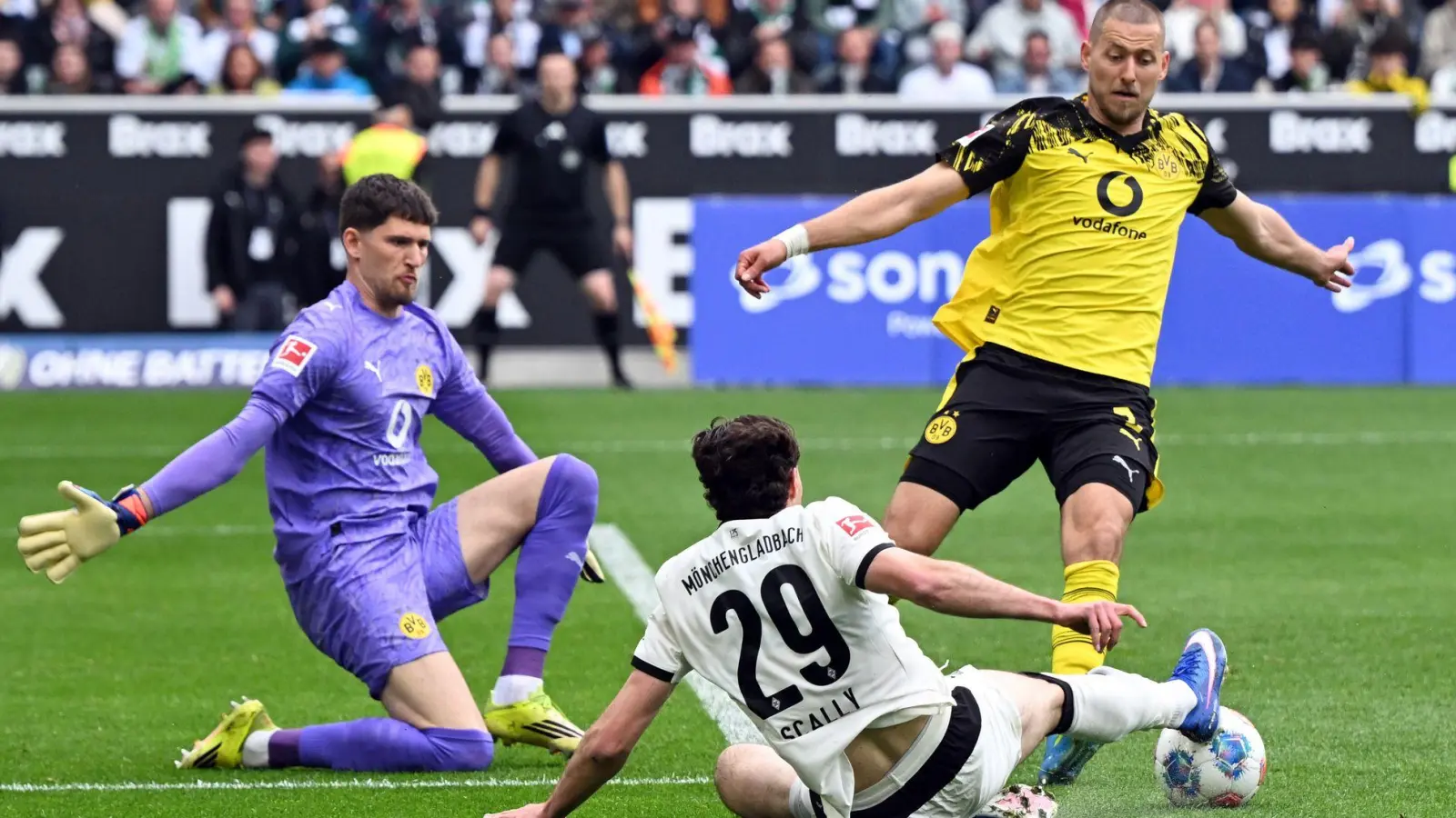 BVB-Torwart Gregor Kobel (l) und Waldemat Anton (r) im Duell mit Gladbachs Joe Scally.  (Foto: Federico Gambarini/dpa)