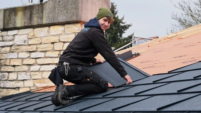 Der Beruf des 20-jährigen Christoph Burggraf ist besonders abwechslungsreich. Bei der aktuellen Baustelle seines Arbeitgebers sind, wie hier zu sehen, Trapezbleche statt klassischer Ziegel gewünscht. (Foto: Luca Paul)