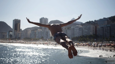 Hitzewelle in Rio de Janeiro: Ein Mann springt ins Meer am Strand Leme.  (Foto: João Gabriel Alves/dpa)