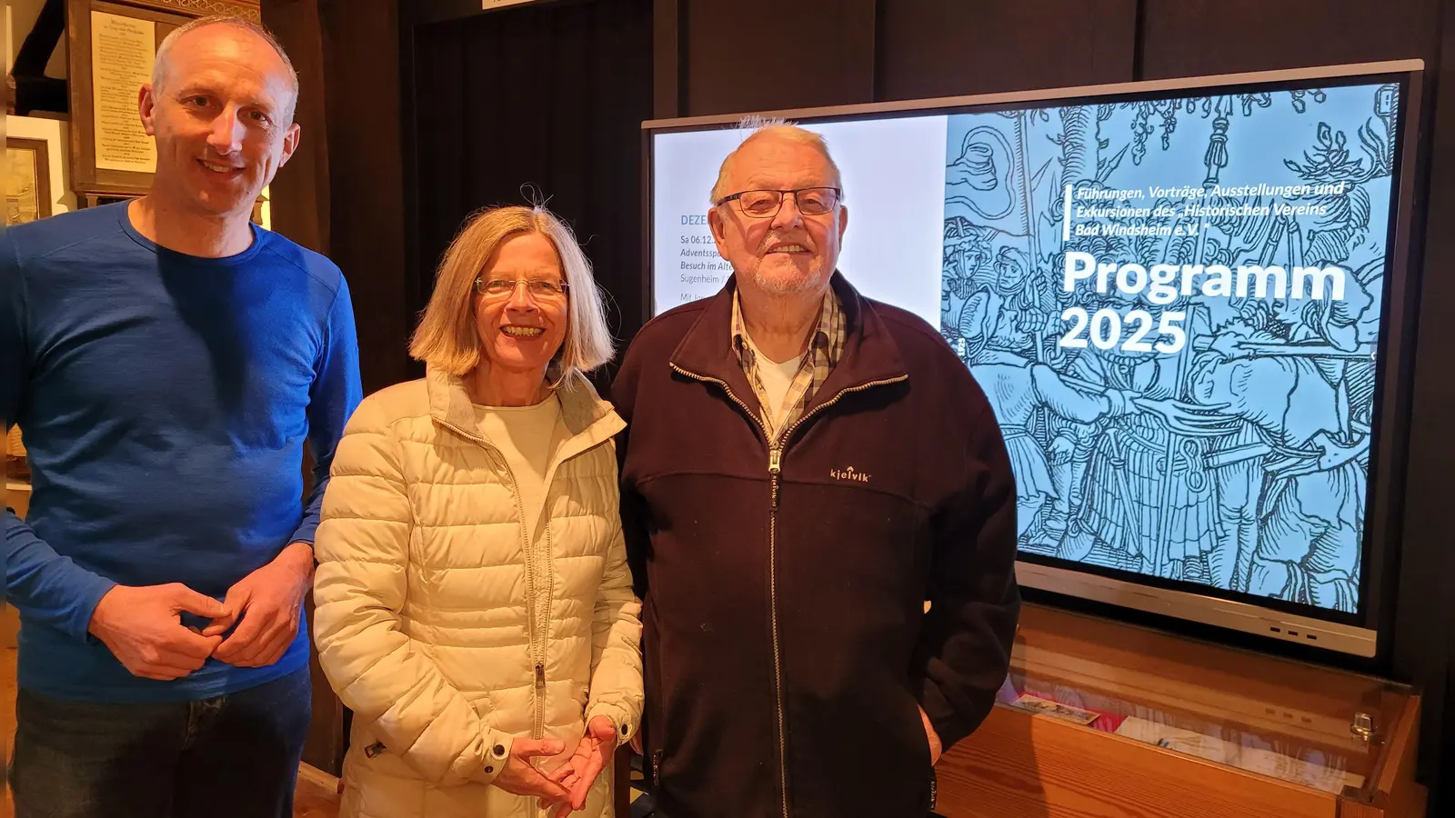 Bernhard Kisch, Dr. Beate Partheymüller und Joachim Schlicke (von links) freuen sich auf das Jahresprogramm 2025 des Historischen Vereins Bad Windsheim. Das lässt sich jetzt auch problemlos über die digitale Schultafel im Eingangsbereich des Museums abrufen. (Foto: Nina Daebel)
