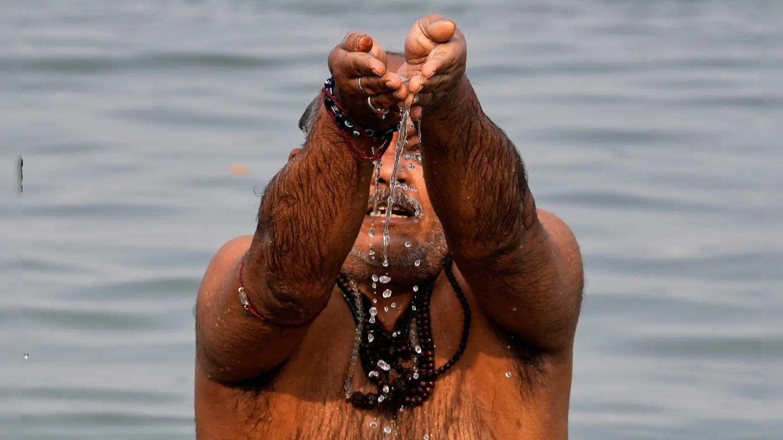 Ein Hindu-Pilger verehrt den Sonnengott während eines rituellen Bades im Hooghly-Fluss anlässlich des Makar Sankranti-Festes in Kolkata. (Foto: Bikas Das/AP/dpa)