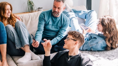 Gemütlich auf der Familiencouch entspannen - auch hier ist es wichtig, die Position regelmäßig zu wechseln, um Rückenschmerzen zu vermeiden. (Foto: Zacharie Scheurer/dpa-tmn/dpa)