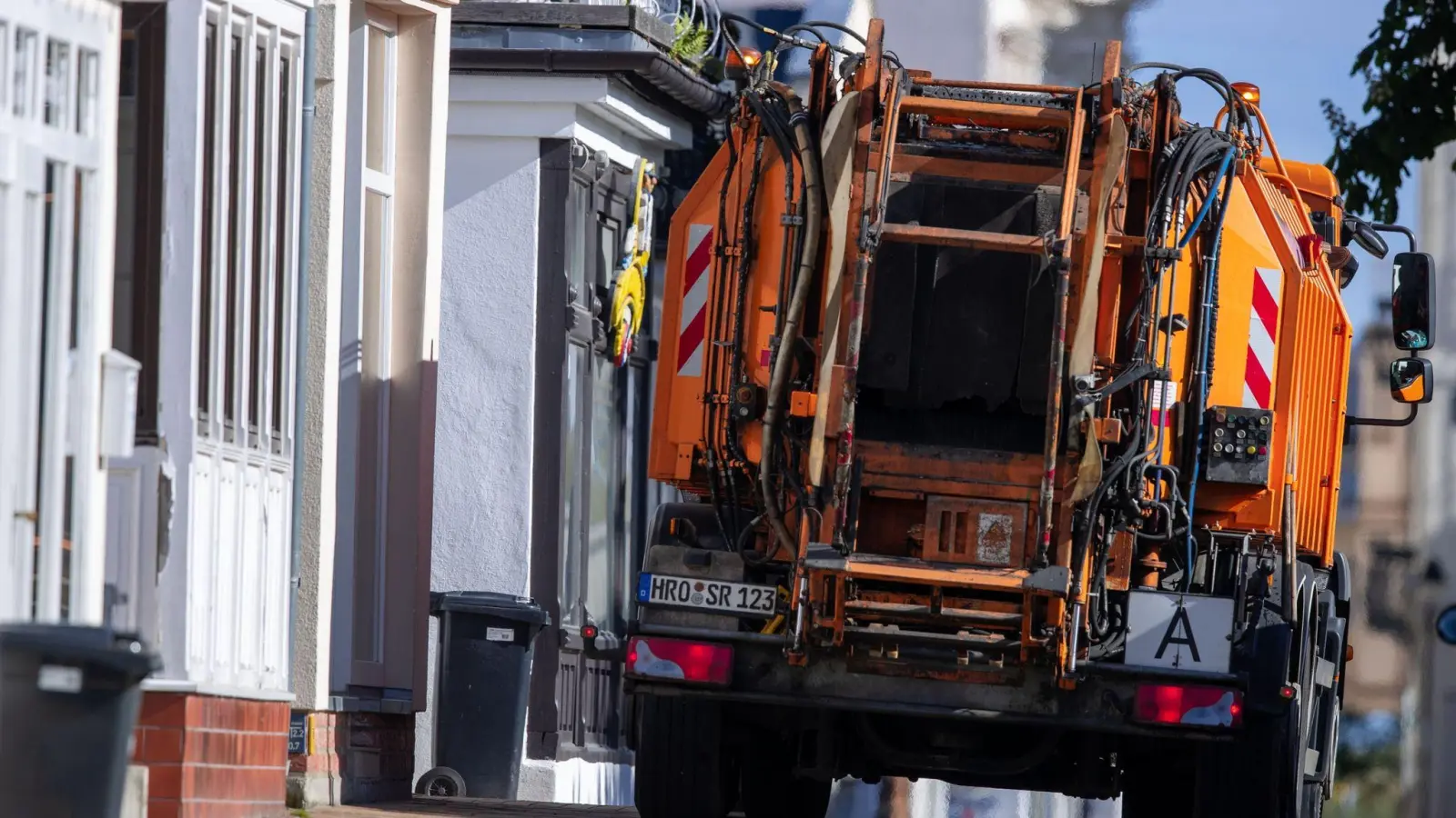 Ein Fahrzeug der Müllabfuhr ist in den engen Straßen in der Altstadt von Warnemünde unterwegs (Symbolbild). (Foto: Jens Büttner/dpa-Zentralbild/dpa)