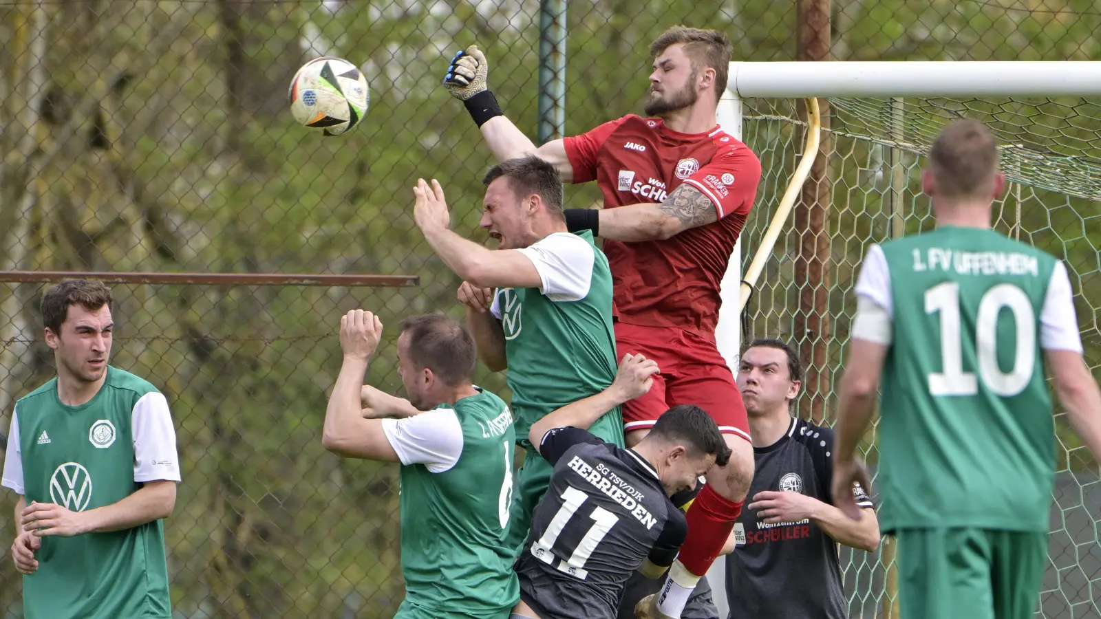 Hier ging es hoch her vor dem Tor von Herriedens Keeper Nico Brinschwitz (in Rot). In den grünen Trikots von links die Uffenheimer Sebastian Zeller, Rainer Gundel, Tobias Kreischer und Uwe Bößendörfer, in den schwarzen Trikots Jonas Schröder und Marcel Skurka von der SG Herrieden. (Foto: Martin Rügner)