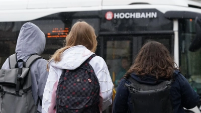 Zwei Schülerinnen und ein Schüler warten in Hamburg auf einen Bus. (Symbolbild) (Foto: Marcus Brandt/dpa)