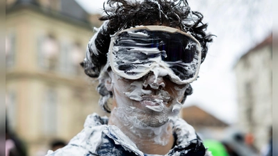 Ein Teilnehmer ist beim „Picoulet” in Genf verkleidet und voller Rasierschaum. Bei dem traditionellen bunten Umzug mit Musik kommt es oft zu wahren Schaumschlachten. (Foto: Salvatore Di Nolfi/KEYSTONE/dpa)