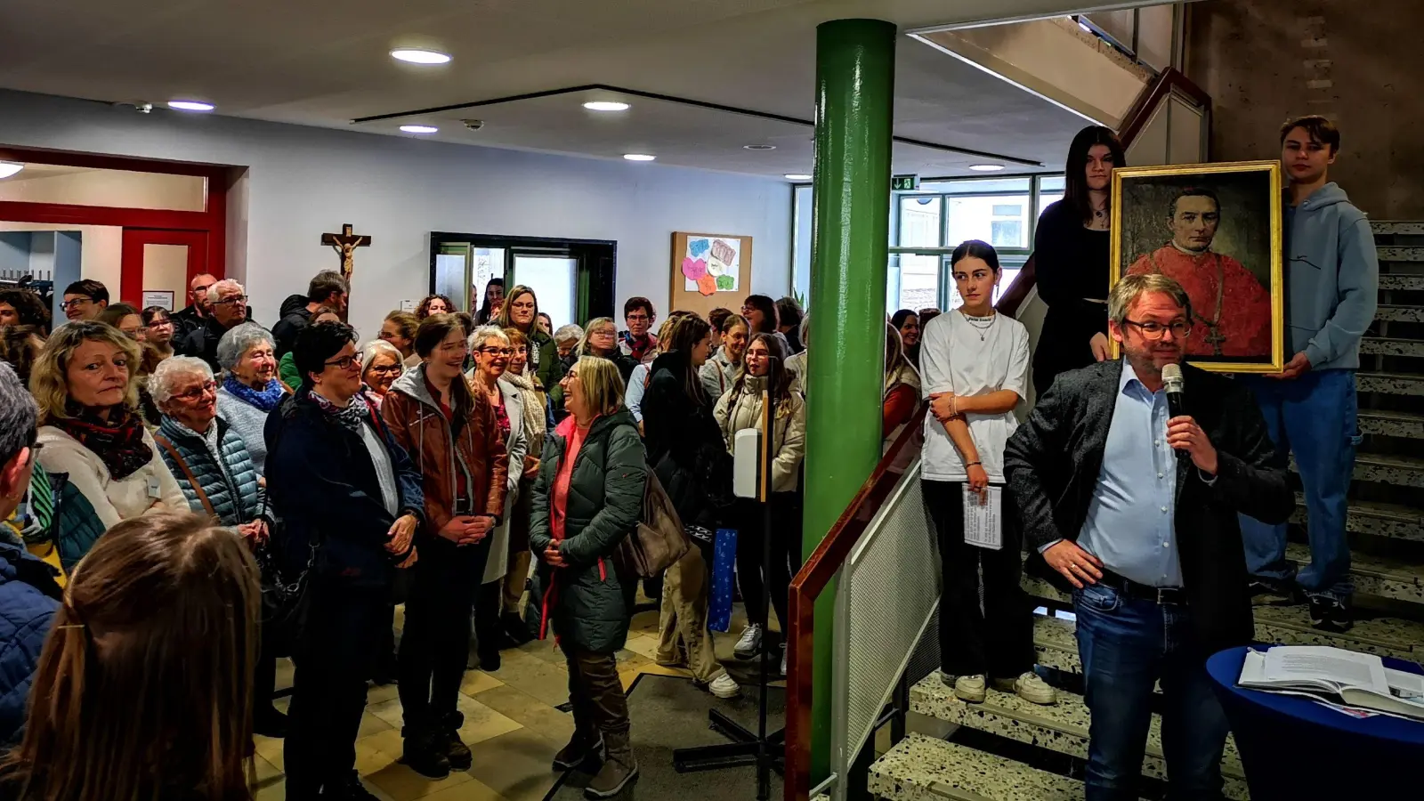 In der Aula trafen sich beim Tag der Begegnung viele ehemalige Schülerinnen. Das Foto zeigt Rektor Marcus Pfalzer bei der Begrüßung und hinter ihm Zehntklässler mit einem Porträt des Stifters Gustav Adolf zu Hohenlohe-Schillingsfürst. (Foto: Jürgen Binder)