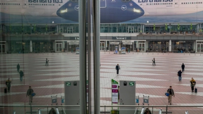 Passanten gehen am Morgen zum Flughafen München. Die Pilotengewerkschaft Vereinigung Cockpit hat für Montag und Dienstag zu Arbeitsniederlegungen bei der Lufthansa und mehreren Tochtergesellschaften aufgerufen. (Foto: Peter Kneffel/dpa)
