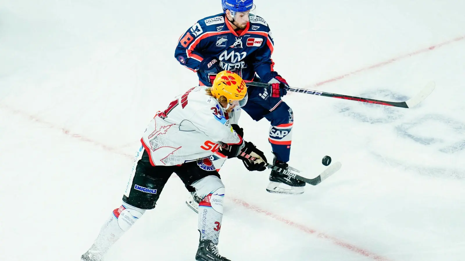 Bremerhavens Philip Samuelsson (vorne) und Mannheims Luca Tosto kämpfen um den Puck. (Foto: Uwe Anspach/dpa/Archivbild)