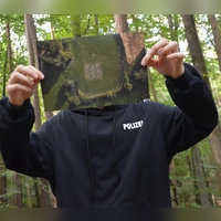 Damit „Ra.g.e.“ unerkannt bleibt, hält er sich ein Drohnenfoto seines QR-Codes vors Gesicht. (Foto: Johannes Zimmermann)