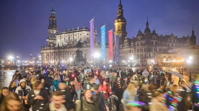 Teilnehmer des Spazierclubs laufen am Abend durch Dresden. (Foto: Robert Michael/dpa)