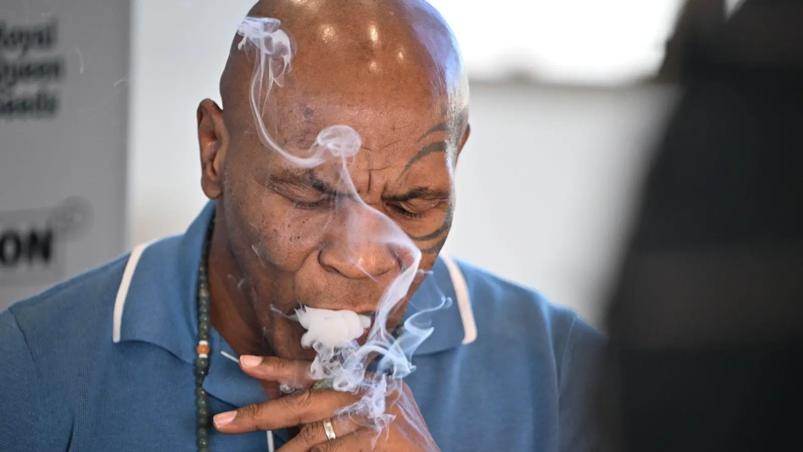 Box-Ikone und Cannabis-Unternehmer Mike Tyson raucht an einem Stand der Cannabis-Messe Mary Jane einen Joint.  (Foto: Sebastian Gollnow/dpa)