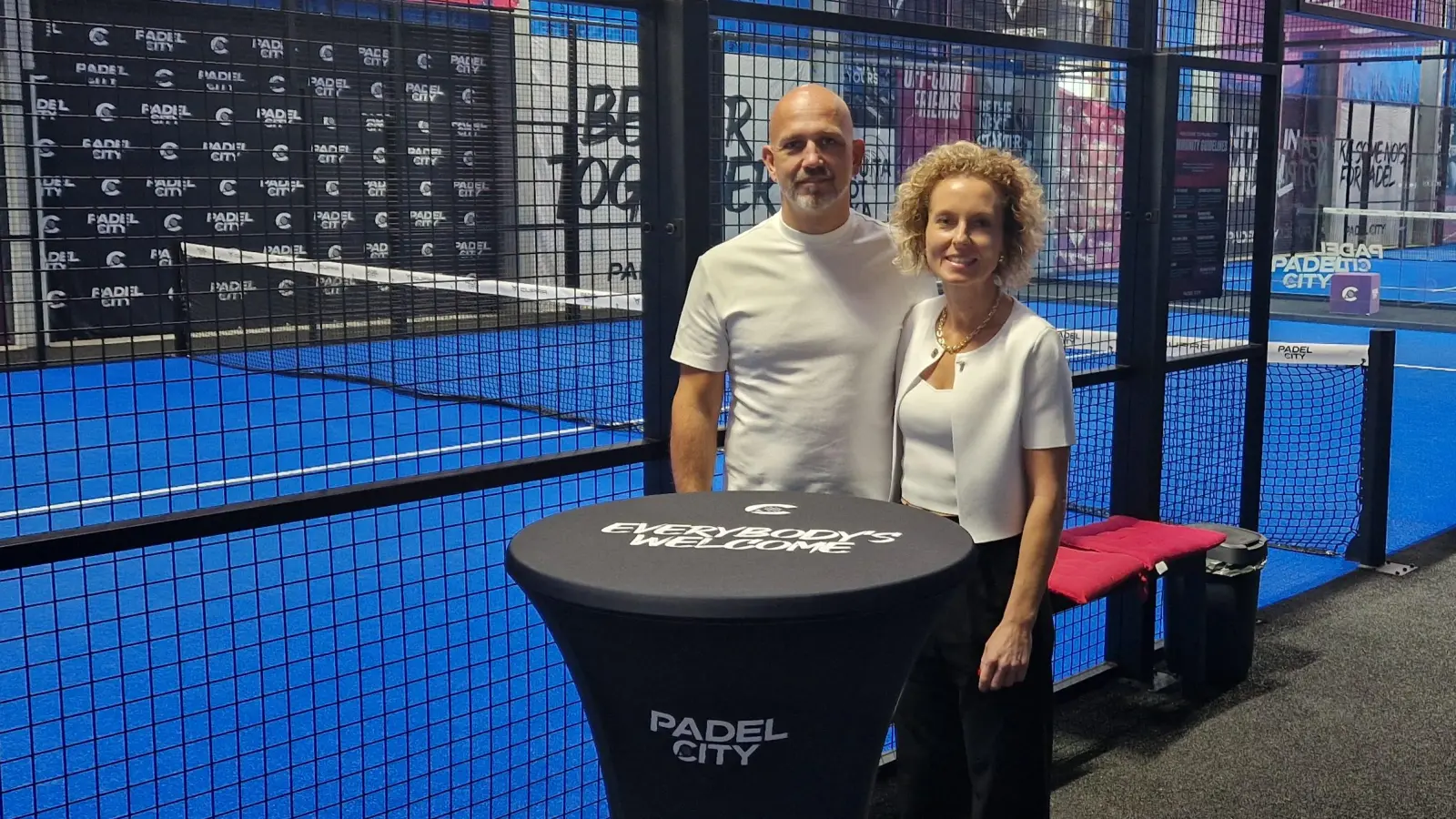 Mit Leidenschaft und Freude zum Sport: Evi und Stefan Glanz stehen in ihrer Halle vor dem Padel-Court. (Foto: Leonie Lang)