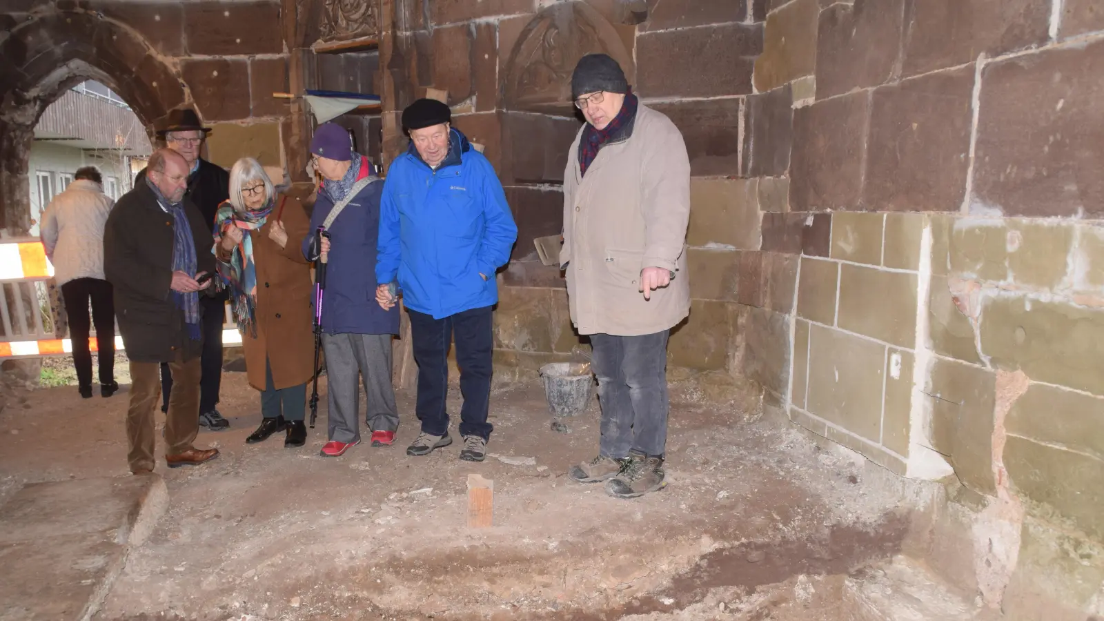Das Dach ist fertig, jetzt geht es im Inneren des Klosterchors weiter. Dort untersucht derzeit der Archäologe Wolfgang Steeger (rechts) den Untergrund. Hier zeigt er den Gästen den von ihm jüngst freigeelgten Altar. (Foto: Gerhard Krämer)