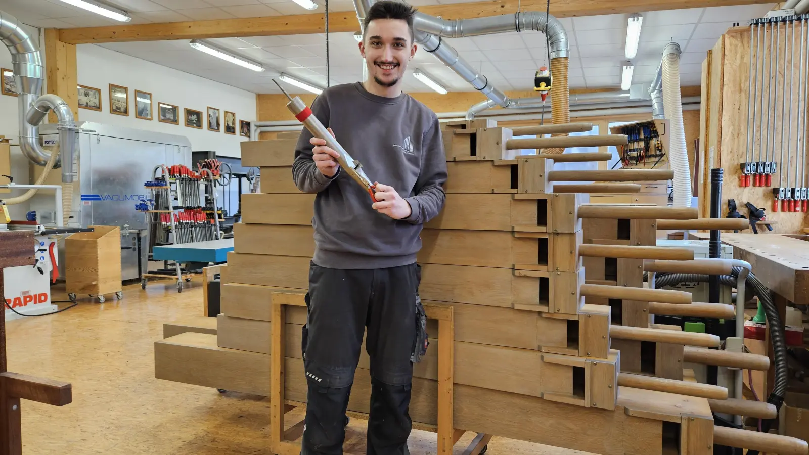 Orgelbauer Christoph Lachmann während seiner Arbeit in der Orgelwerkstatt: In seiner Hand hält er eine Orgelpfeife aus Metall. (Foto: Sebastian Roßkopf)