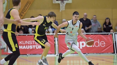 Vier Sekunden vor der Schlusssirene traf Raul Dumnici (im weißen Trikot) zum 69:68-Sieg für seine Ansbach Piranhas gegen die TS Jahn München (Pirmin Gaisser). (Foto: Martin Rügner)