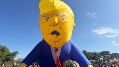 Ein aufblasbarer Ballon mit dem Abbild von US-Präsident Donald Trump ragt über eine Menschenmenge während einer „No Kings“-Demonstration. (Foto: Anna Ringle/dpa)