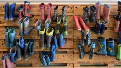 Gummistiefel hängen an der Palettenwand einer Kindertagesstätte in Halle (Saale). In Deutschland fehlen Erzieherinnen und Erzieher. (Foto: Heiko Rebsch/dpa)