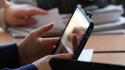 Schüler mit einem Tablet: Den Schulleitungen zufolge fehlt Geld für die Digitalisierung. (Foto: Soeren Stache/dpa)