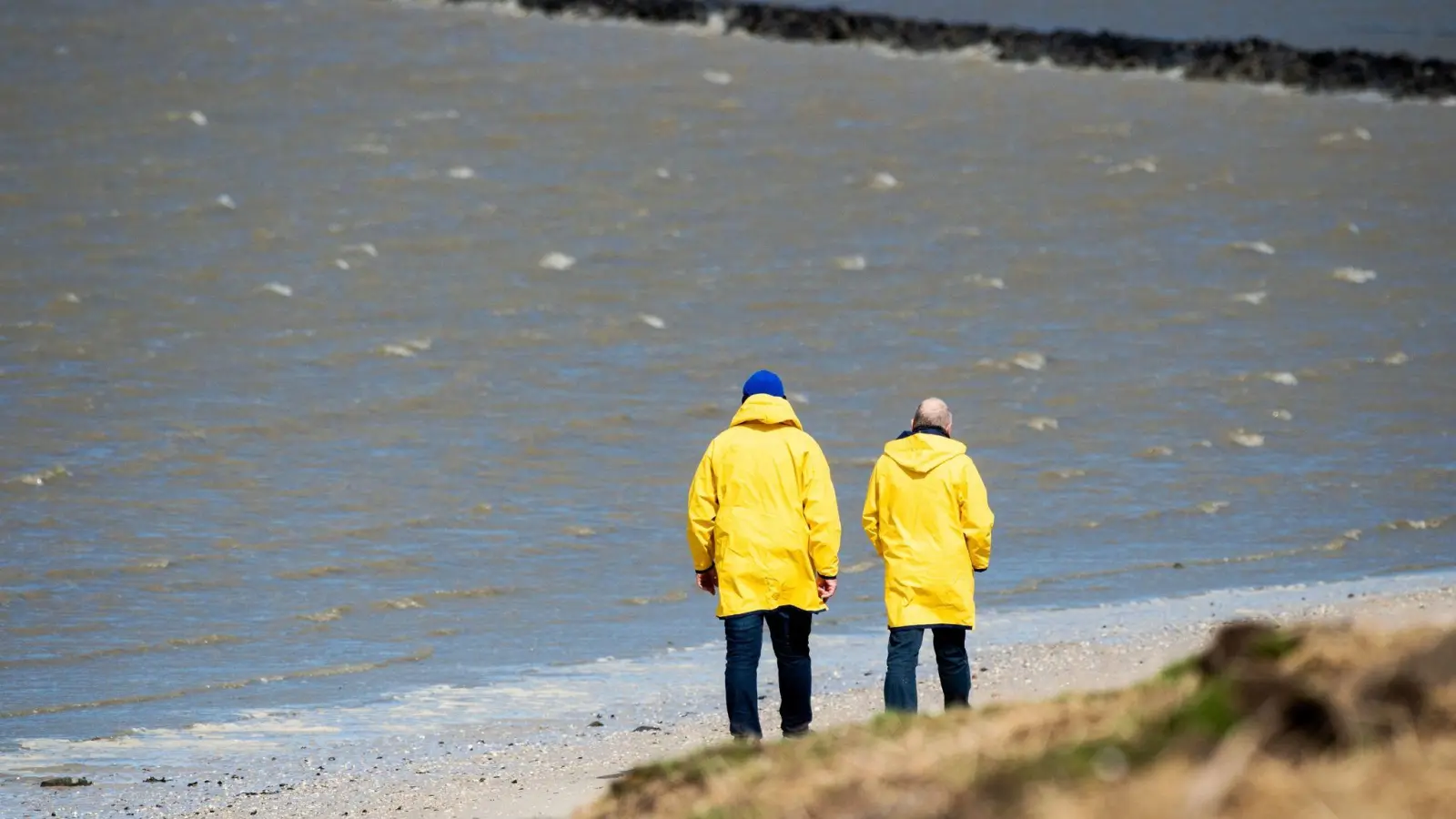 Noch immer das passende Kleidungsstück bei stürmischem Wetter: der Regenmantel. (Foto: Hauke-Christian Dittrich/dpa)