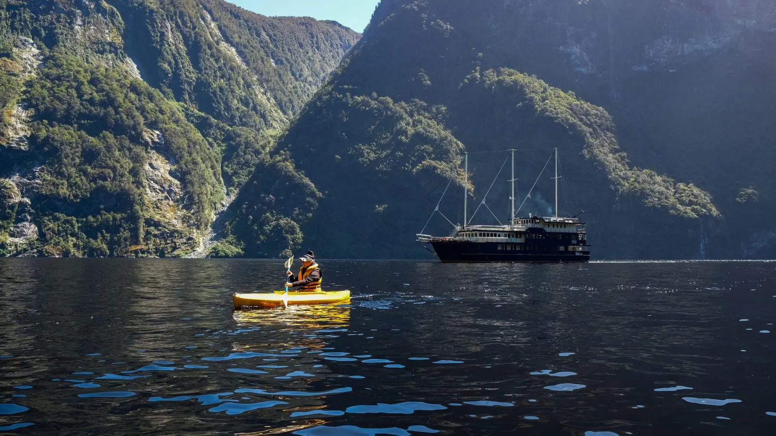 Ausflug im Padelboot im Crooked Arm. Die „Fiordland Navigator“ wartet derweil. (Foto: Florian Sanktjohanser/dpa-tmn)