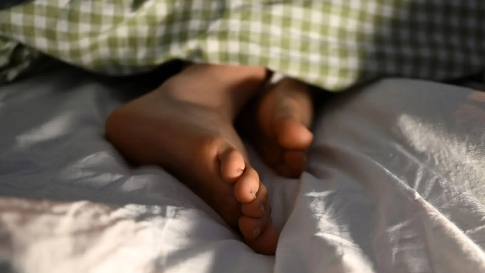 Hilft bei warmen Sommernächten nur bedingt gegen Schwitzen: Die Füße aus der Decke gucken lassen. (Foto: Elisa Schu/dpa/dpa-tmn)