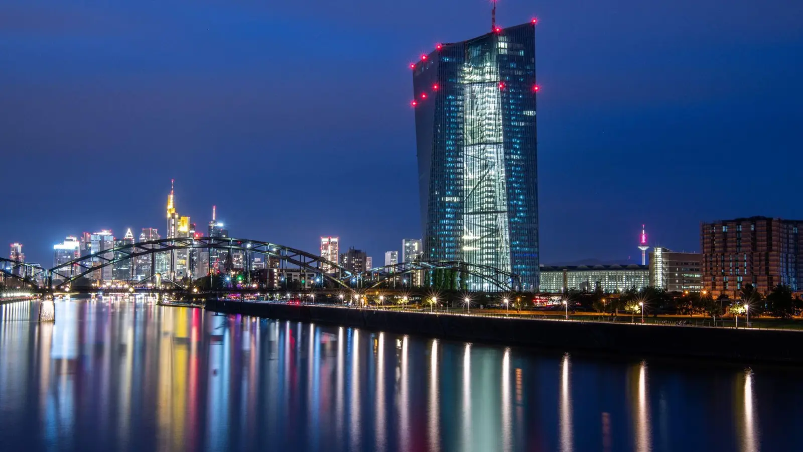 Die Lichter der Frankfurter Bankenskyline und der Europäischen Zentralbank (EZB) spiegeln sich im Main. (Foto: Boris Roessler/dpa)