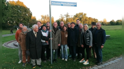 Nach der Umbenennung des Inselwegs zur „Sebastian-Sprenz-Promenade“ versammelten sich die Teilnehmer an der Enthüllung am Schild mit der neuen Aufschrift. Dr. Rudolf springholz und OB Dr. Christoph Hammer mit der Hand am Schild zusammen mit Stadträten, einem Teil der Familie des Referenten und Mitgliedern des Historischen Vereins, der Kinderzeche und der Verwaltung. (Foto: Friedrich Zinnecker)