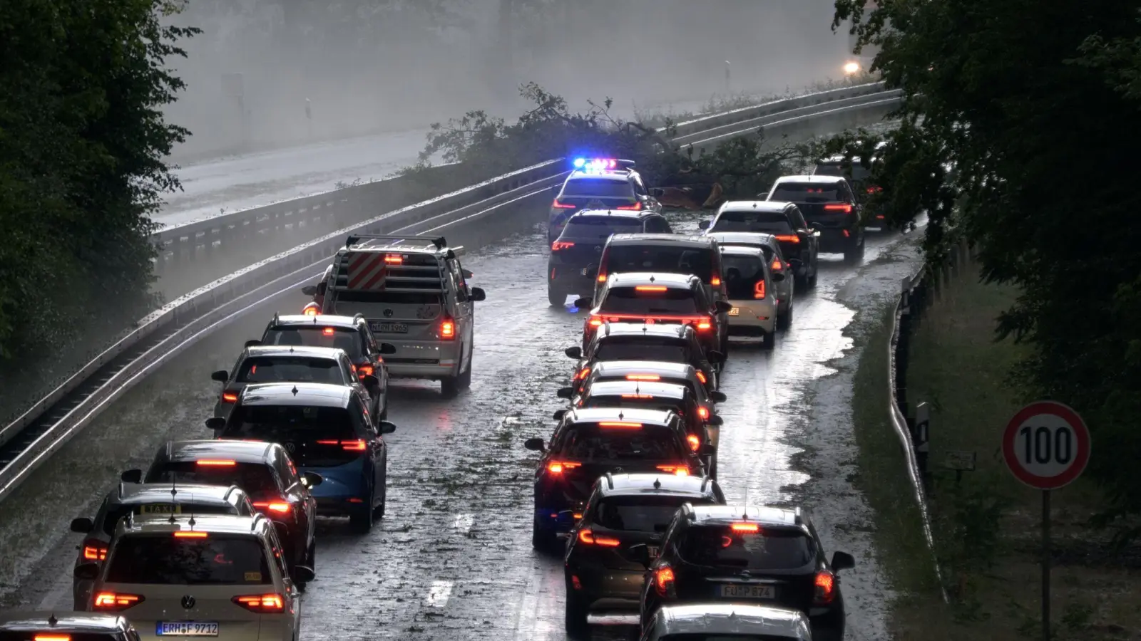 Die Polizei leitet den Verkehr auf der Bundesstraße 4 bei Erlangen-Tennenlohe an umgestürzten Bäumen vorbei. (Foto: Bernd März/Fotoreportextremwetter.tv/dpa)