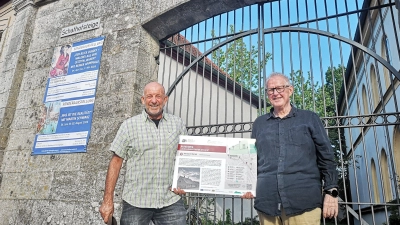 Markus Löschel (links) und Johannes Munique sind in Schillingsfürst die Macher in Sachen Jenisch. Das Foto zeigt die beiden vor dem Tor zu dem kleinen Museum, das der Sondersprache gewidmet ist. Ihr neuestes Projekt ist ein Rundweg mit mehreren Themenstationen. Die dafür nötigen Infotafeln sind fertig. (Foto: Jürgen Binder)