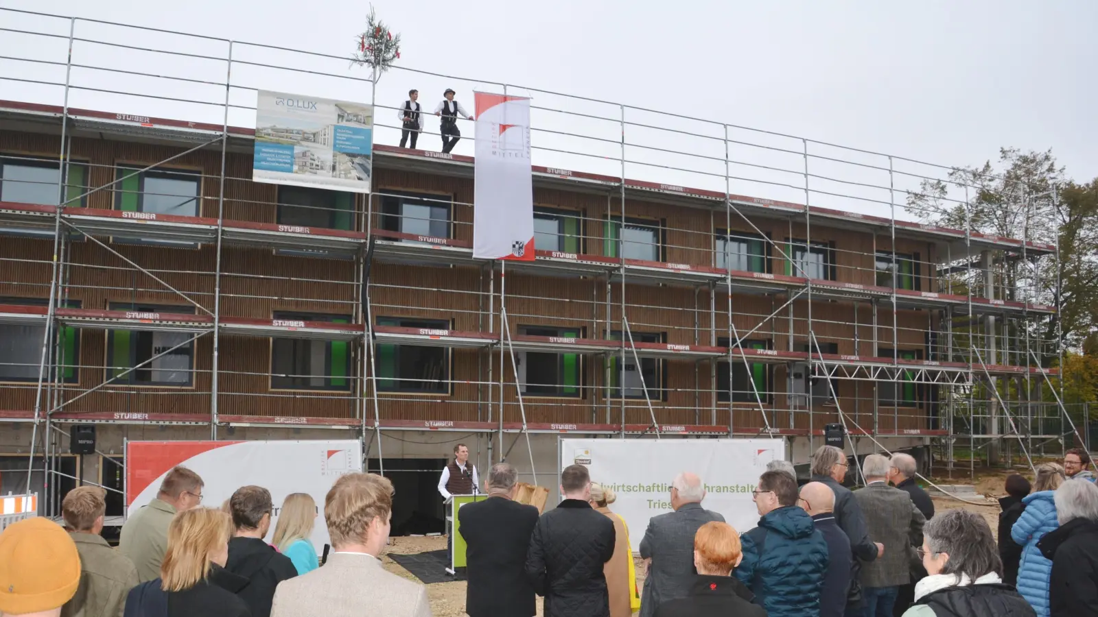 Markus Heinz, Leiter der Landwirtschaftlichen Lehranstalten Triesdorf (in der Mitte am Stehpult), begrüßte die Ehrengäste sowie Handwerkerinnen und Handwerker zu Beginn des Richtfests für das neue Gästehaus „Am Weidenbacher Tor”. (Foto: Peter Tippl)