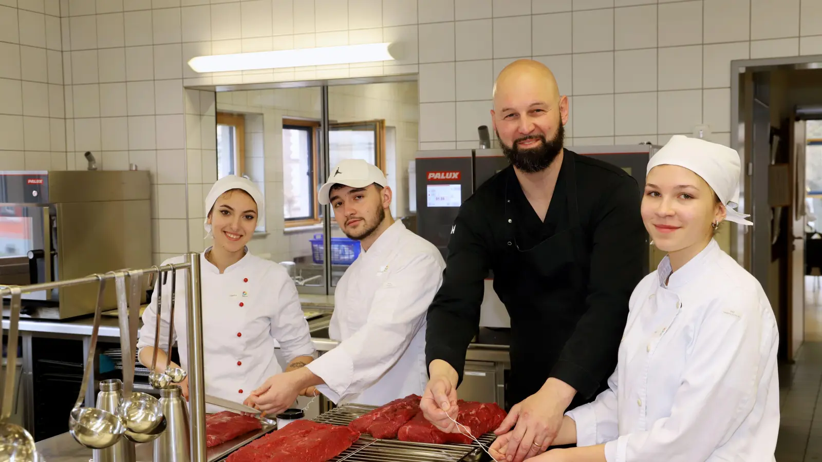 Gianina Daroti (links), Cristian Antoci (Zweiter von links) und Leni Fleischmann lassen sich am Beruflichen Schulzentrum Ansbach-Triesdorf ausbilden. Jetzt arbeiteten sie mit Küchenmeister Jörg Hibbard. (Foto: Oliver Herbst)